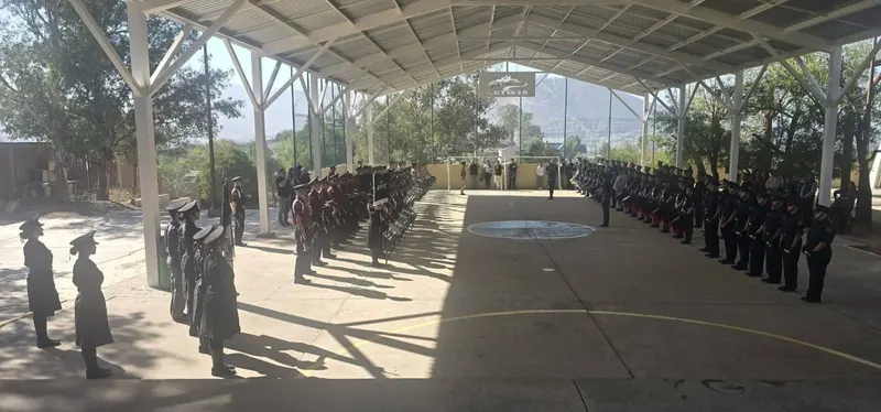 Bandas de guerra y escoltas formadas en una cancha techada durante un concurso